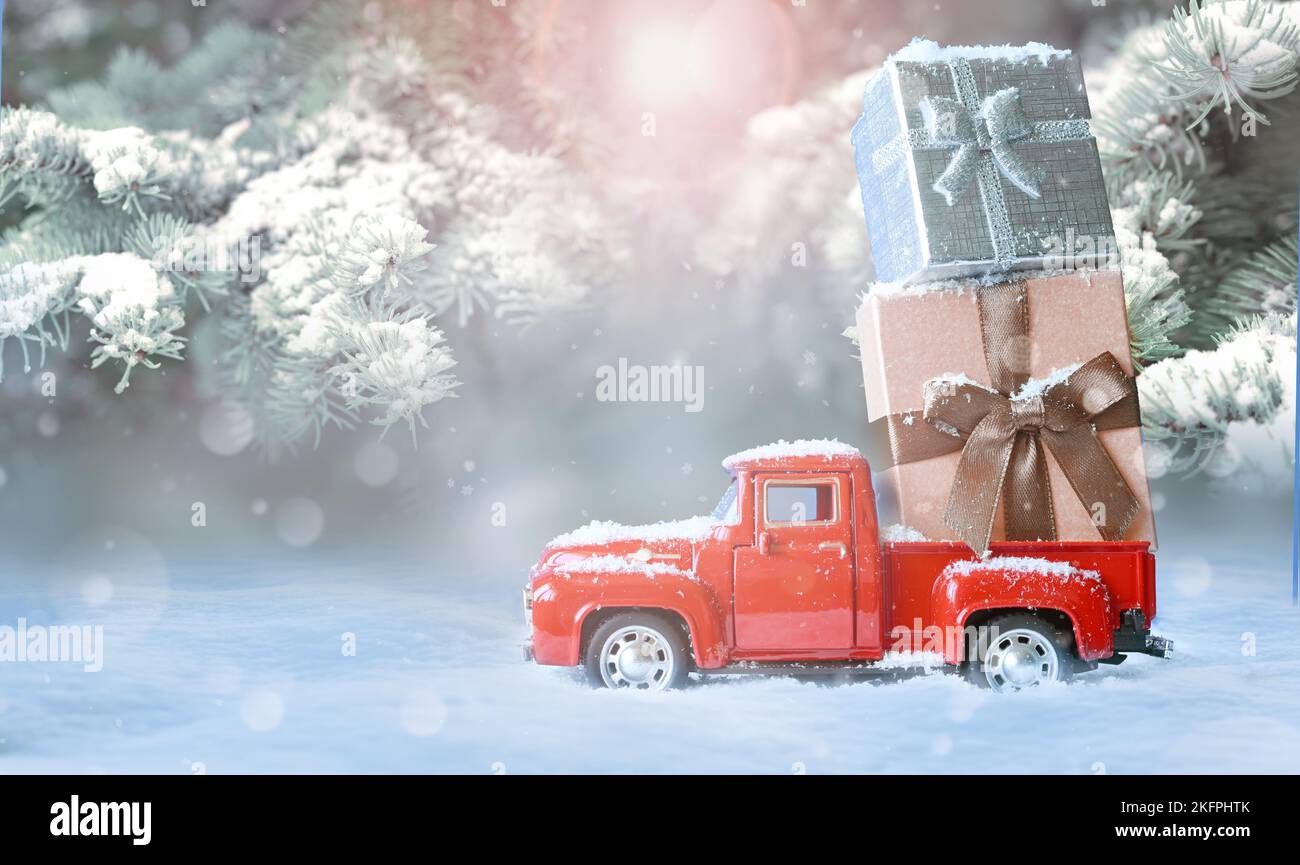 Weihnachten Hintergrund mit Schnee und Retro-roten Auto mit Geschenkbox. Frohe Weihnachten und frohe Neujahrsgrusskarte mit Kopierplatz Stockfoto