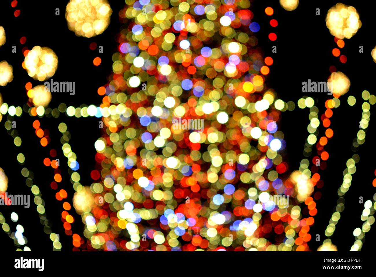 Weihnachtsbaum des neuen Jahres, geschmückt mit leuchtenden bunten Girlanden und Beleuchtung in der Nacht. Weihnachtsbaum mit blinkenden Lichtern. Unscharfer Hintergrund. Neujahr Weihnachtsferien. Stockfoto