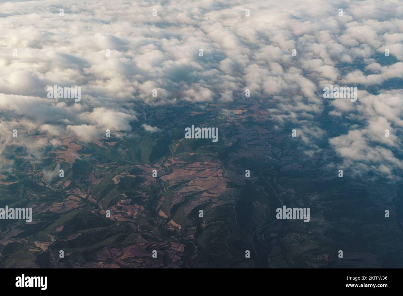 Weiße Wolkenlandschaft mit Blick durch braune und grüne Berge in einer spanischen Landschaft Stockfoto