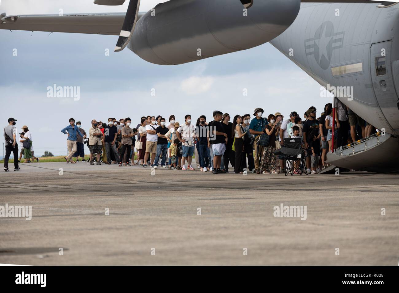 Status of Forces Agreement während der Futenma Flight Line Fair auf der Marine Corps Air Station Futenma, Okinawa, Japan, 1. Oktober 2022 stehen Mitarbeiter und lokale Staatsbürger Schlange, um eine Lockheed Martin KC-130 zu sehen. Das Personal und die lokalen Staatsbürger nahmen an der Messe der Marine Corps Community Services Teil, um lokale Anbieter zu sehen, an Spielen teilzunehmen und Live-Musikaufführungen zu sehen; sie halfen dabei, eine stärkere Allianz zwischen den Vereinigten Staaten und Japan zu bilden. Stockfoto