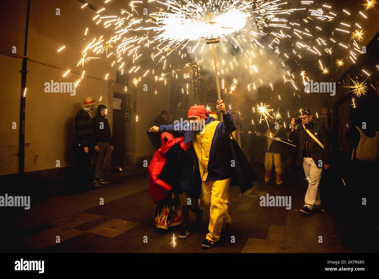 Barcelona, Spanien. 19.. November 2022. Ein ‘Correfoc' (Feuerläufer) zündet sein Feuerwerk unter einer jubelnden Zuschauermenge an, die den 40.. Jahrestag der 'Diabolica de Gracia' feiert. Quelle: Matthias Oesterle/Alamy Live News Stockfoto