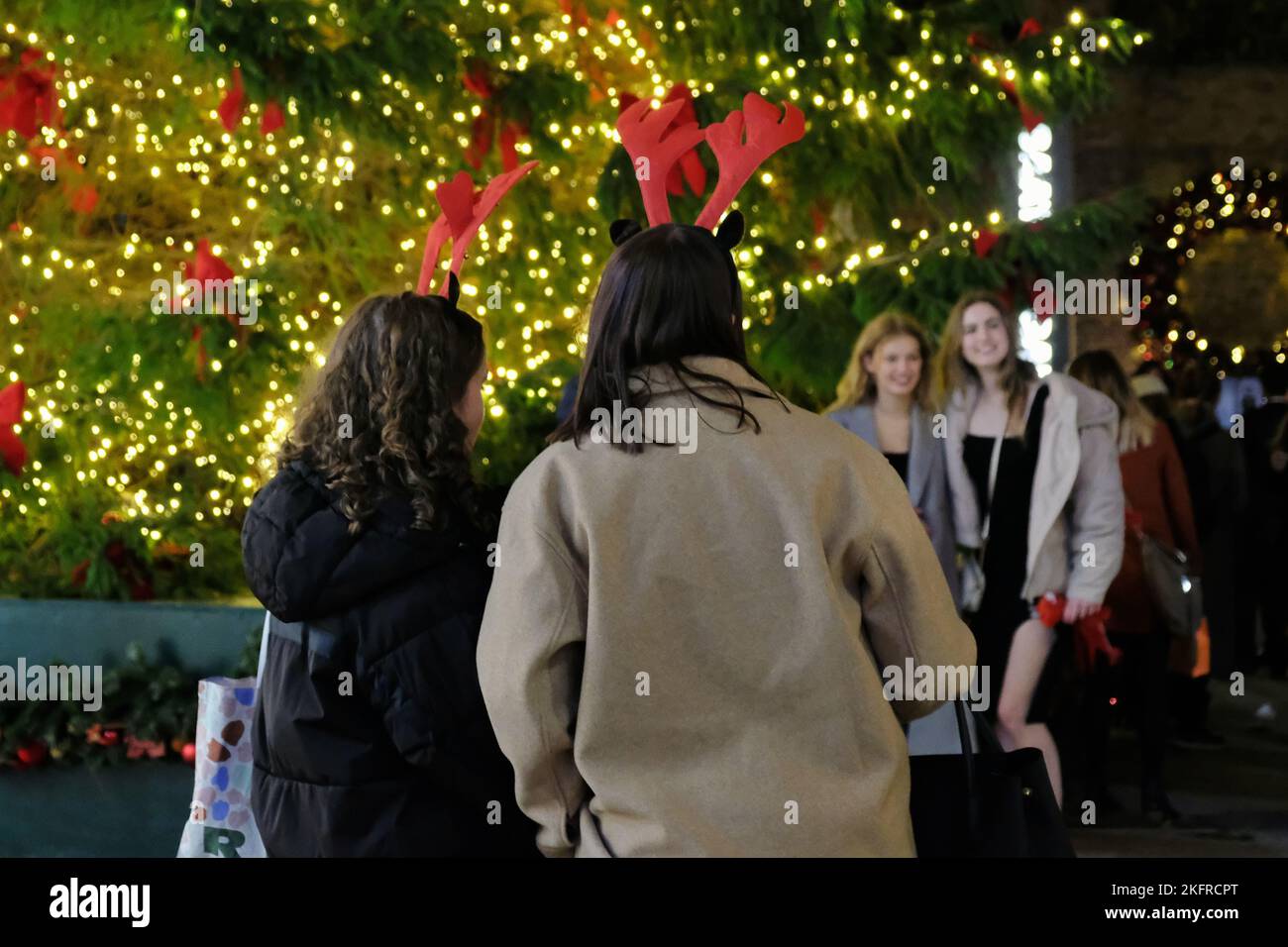 London, Großbritannien. 19.. November 2022. Zwei Frauen tragen Filzwildgeweihe, während sie Menschen beim Fotografieren an einem Weihnachtsbaum zusehen. Die weihnachtliche Lichtumschaltung in der King's Road zog zahlreiche Besucher in die Umgebung, während die Menschen in den festlichen Geist eindrang. Kredit: Elfte Stunde Fotografie/Alamy Live Nachrichten Stockfoto