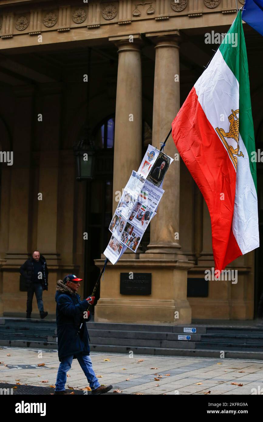 Frankfurt Am Main, Deutschland. 19.. November 2022. Ein Protestler schwenkt die iranische Flagge und plakiert sie während der Demonstration. Das iranische Volk protestiert in Frankfurt am Main zum dritten Jahrestag des „blutigen Novembers“ und zur Unterstützung der iranischen Revolution gegen das Regime der Islamischen Republik Iran. Kredit: SOPA Images Limited/Alamy Live Nachrichten Stockfoto