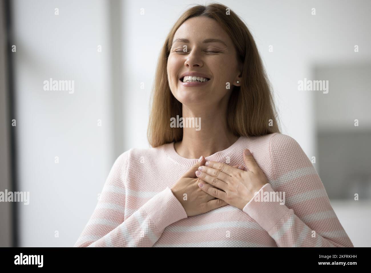 Frau legte gefaltete Handflächen auf die Brust und fühlte Dankbarkeit zum Ausdruck bringen Stockfoto