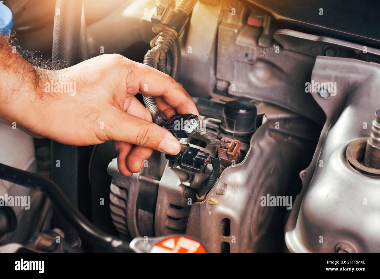 Die Auto-Mechaniker Hand greift die Auto-Generator-Ladegerät Stecker Stockfoto