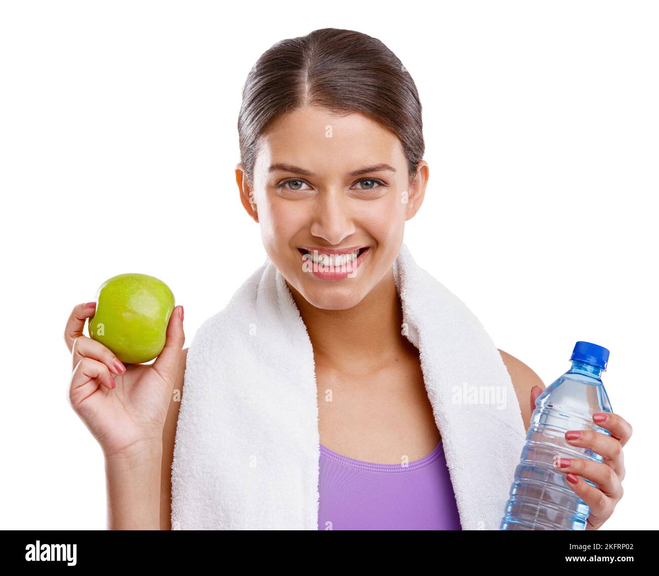 Eine schöne junge Frau, die einen frischen grünen Apfel und eine Flasche Wasser in der Hand hält. Stockfoto