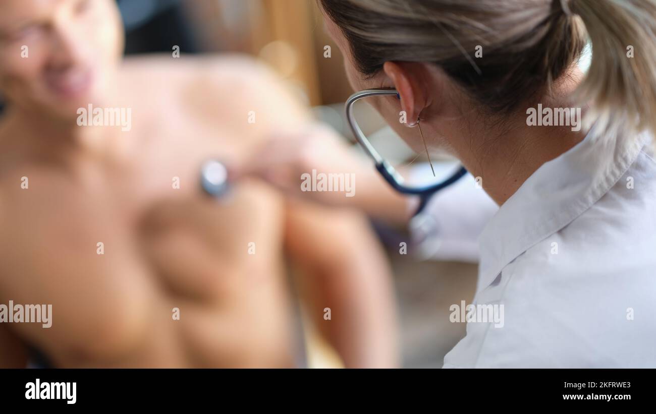 Ärztin, die Stethoskop verwendet, um die Atmung oder den Herzschlag des Patienten zu überprüfen. Stockfoto
