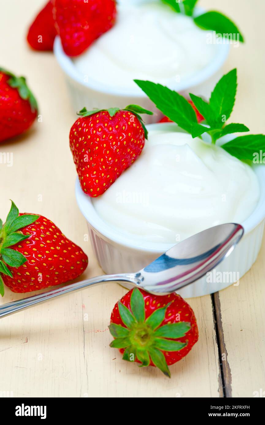 Griechischer Bio-Joghurt und Erdbeere auf dem weißen rustikalen Holztisch Stockfoto