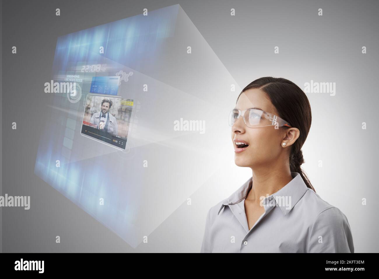 Shes erhielt Zugang zu den aktuellsten Nachrichten. Eine Frau mit einer intelligenten Brille, die eine Projektion einer Live-Nachrichtenübertragung ansah. Stockfoto