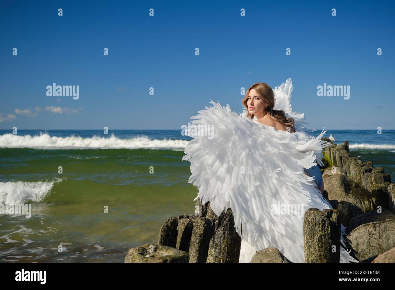 Eine junge schöne Frau Engel mit weißen Flügeln am Strand Stockfoto