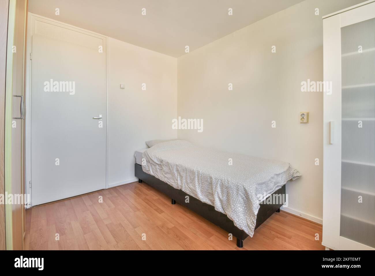 Modernes Bett mit bequemer Matratze im geräumigen Schlafzimmer Stockfoto