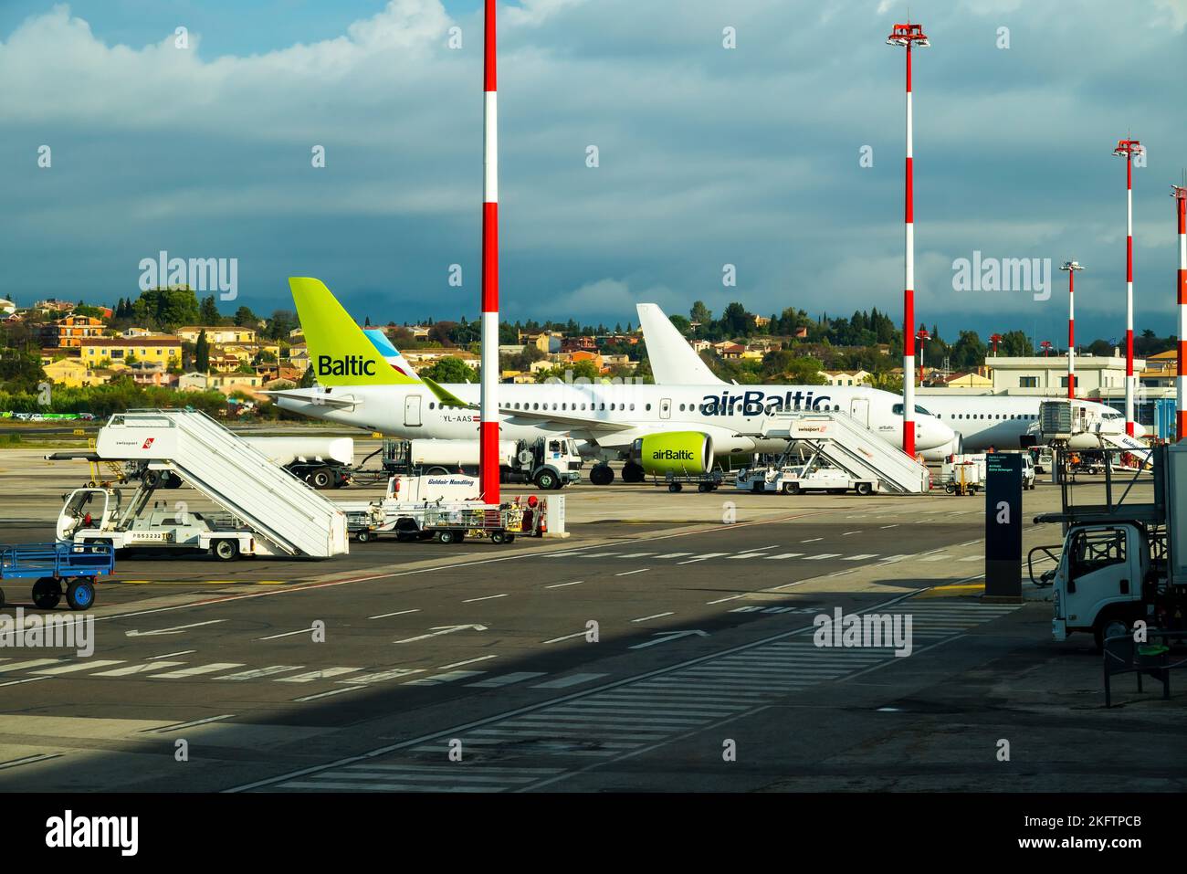 Kerkyra, Griechenland - 09 29 2022: Blick auf den Flughafen Korfu auf dem grünen Flugzeug von AirBaltic. Parkplatz Für Flugzeuge, Flugzeug Wird Vor Dem Start Betankt, Gegen Stockfoto