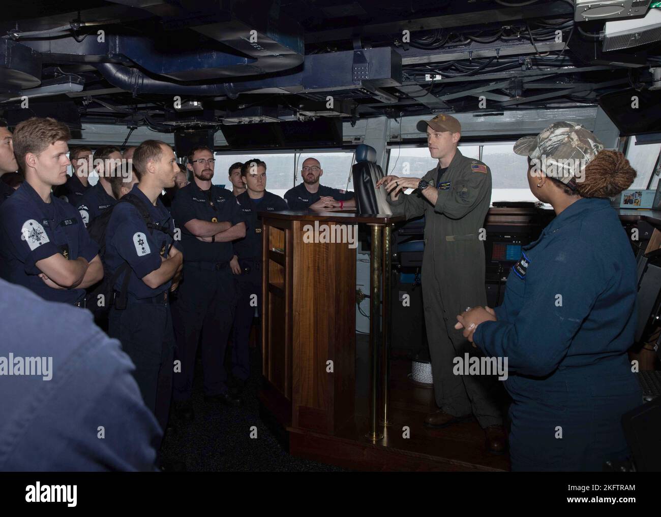 221007-N-EL850-2091 SOUDA BAY, Kreta (Okt 7, 2022) LT. Andrew Whelan, dem Flugzeugträger USS George H.W. der Nimitz-Klasse zugeordnet Bush (CVN 77), diskutiert Brückenoperationen mit Matrosen der Royal Navy, die dem Luftverteidigungszerstörer HMS Defender (D 36) der gewagten Klasse zugewiesen wurden, während einer Tour des Schiffes in Souda Bay, Kreta, am 7. Oktober 2022. The George H.W. Die Bush Carrier Strike Group befindet sich im geplanten Einsatzgebiet der US Naval Forces Europe, das von der Sechsten Flotte der USA eingesetzt wird, um die Interessen der USA, der Alliierten und der Partner zu verteidigen. Stockfoto