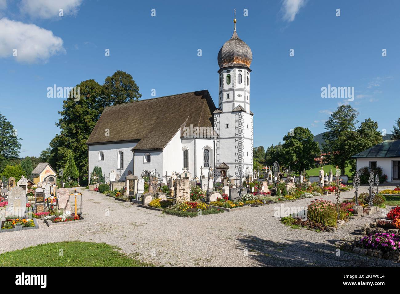 Die barocke katholische Kirche zum Schutz der Jungfrau Maria, umgeben von Gräbern des Friedhofs Fischbachau, Bayern, Deutschland Stockfoto