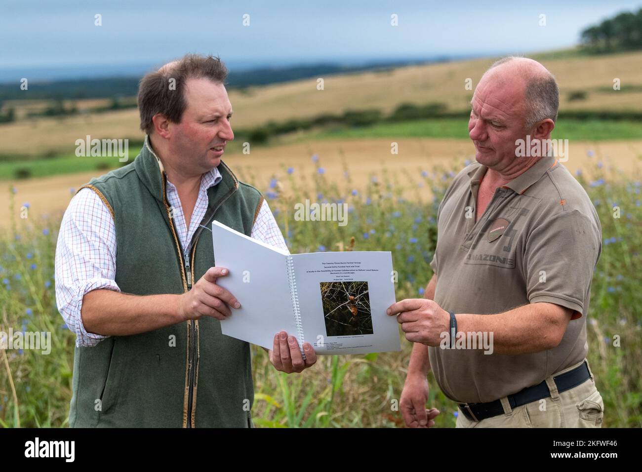 Landagent und Landwirt diskutieren über die Betriebsführung auf einem Ackerbaubetrieb in Northumberland, Großbritannien. Stockfoto