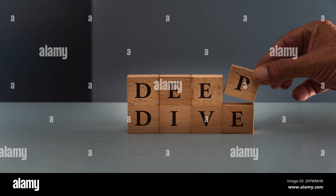 Deep Dive, Buzz Wort, Hand posing Holzblock, Konzept der Analyse oder erkunden Stockfoto