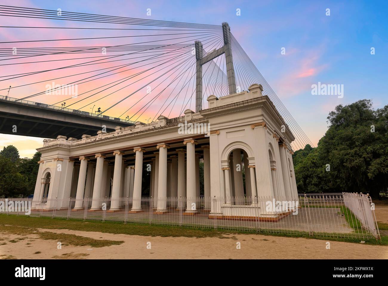 Denkmalgeschützte Architektur im Kolonialstil im Princep Ghat Kolkata, Indien, mit Blick auf die Vidyasagar Setu-Seilbahn, die bei Sonnenaufgang die Brücke hielt Stockfoto