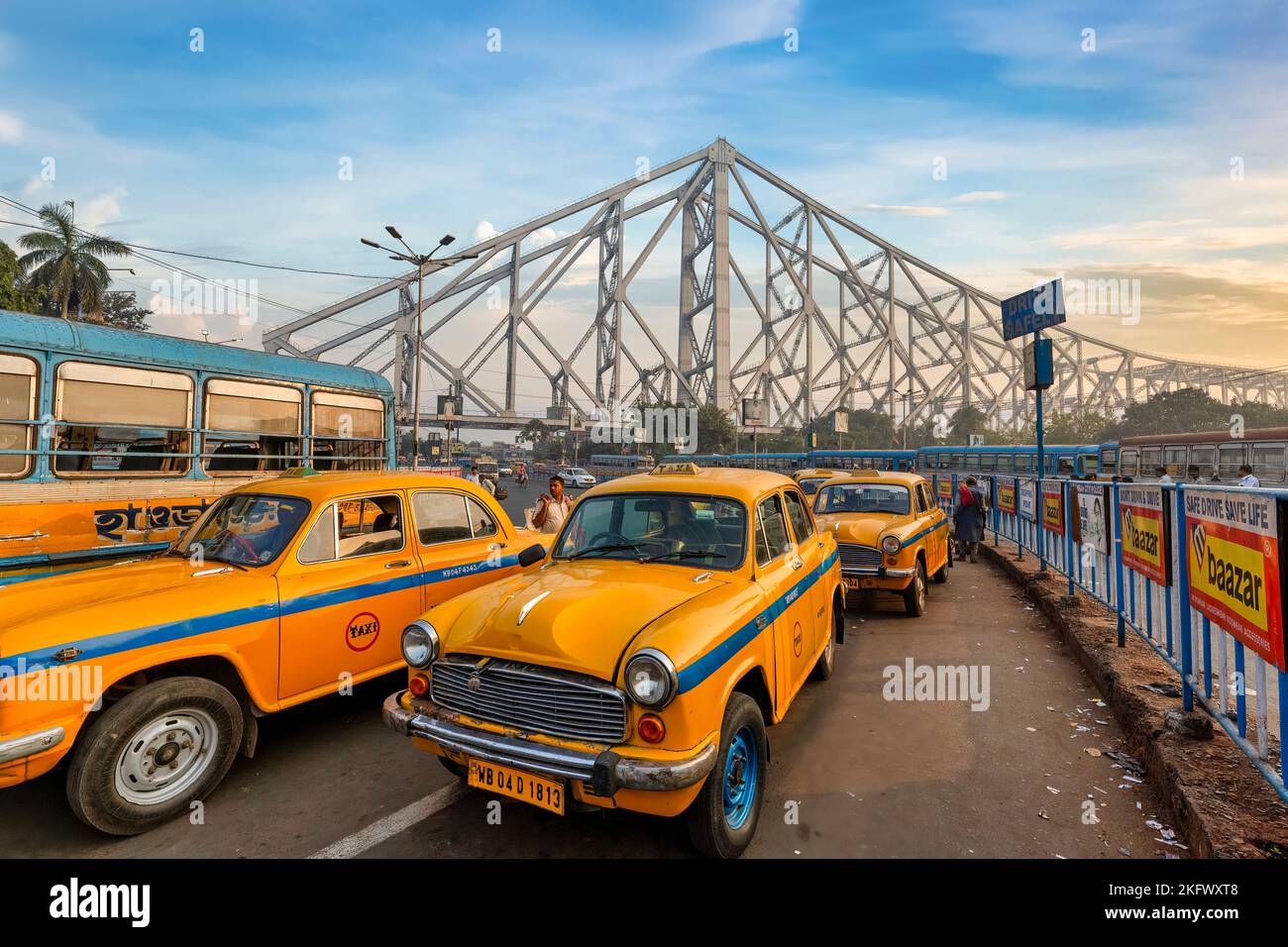 Gelbes Taxi parkt an der Stadtstraße nahe der historischen Howrah Brücke bei Sonnenaufgang. Foto in der Nähe des Bahnhofs Howrah in der Stadt Kalkutta Indien. Stockfoto