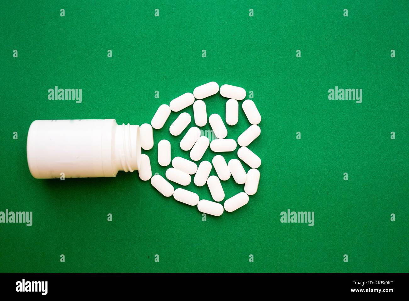 Pillen, Tabletten, Pillenflasche isoliert auf grün. Draufsicht mit Kopierbereich. Medizin Pharmazie Pharmakologie Gesundheitskonzept Stockfoto