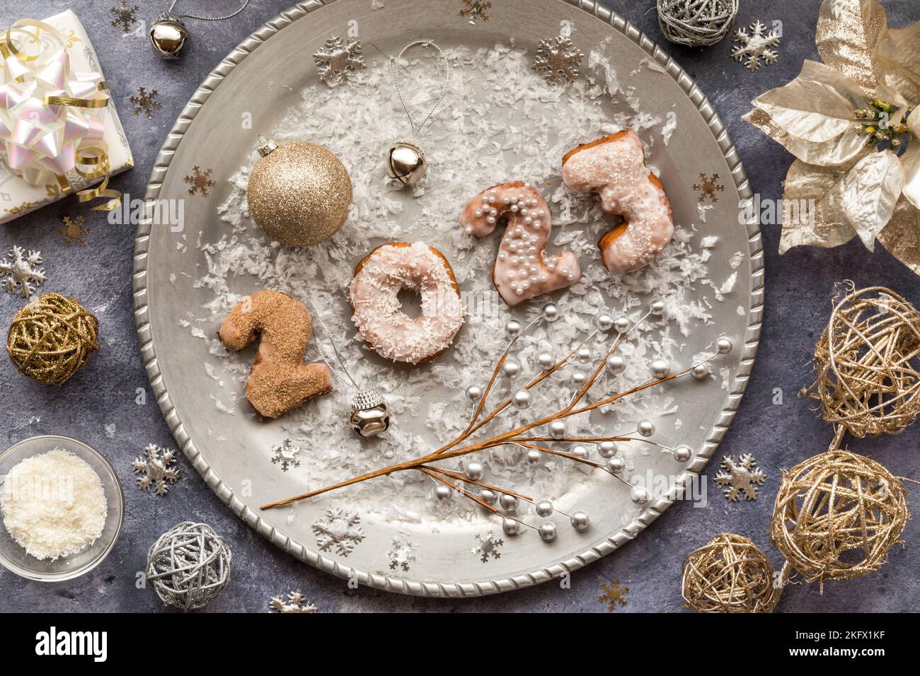 Weihnachtsdonuts für 2023 auf einem silbernen Tablett, umgeben von festlichen Dekorationen. Stockfoto
