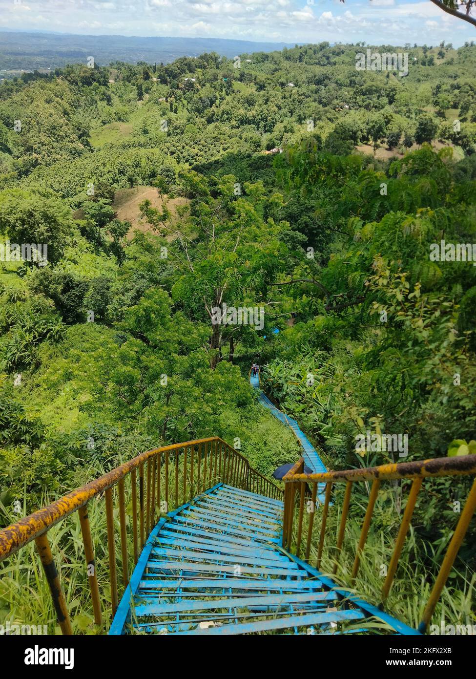 Eine vertikale Aufnahme von blauen schmalen steilen Treppen, die von einem grünen Wald umgeben sind, im Distrikt Khagrachhari in der Chittagong Division von Bangladesch Stockfoto