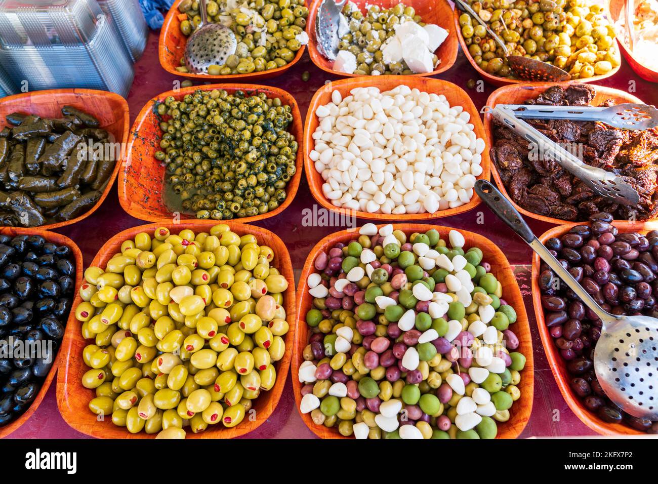 Oben Nahaufnahme von 11 Körben mit verschiedenen Olivenarten auf einem Marktstand. Stockfoto
