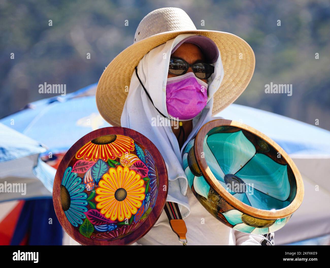 Cabo San Lucas, Mexiko - 7. November 2022 - Ein lokaler Verkäufer bietet an einem sonnigen Tag bunte Schalen zum Verkauf an Stockfoto
