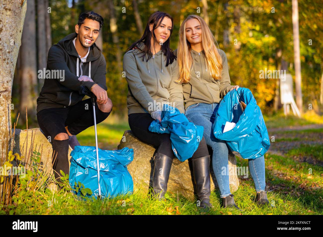 Fokussiertes Team junger Freiwilliger, die Müll sammeln, um die Umwelt zu schützen Stockfoto
