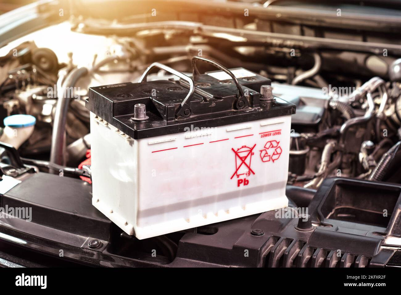 Die Autobatterie der Automobilelektrik im Motorraum für die Autowartung und recyceln Elektronikmüll Stockfoto