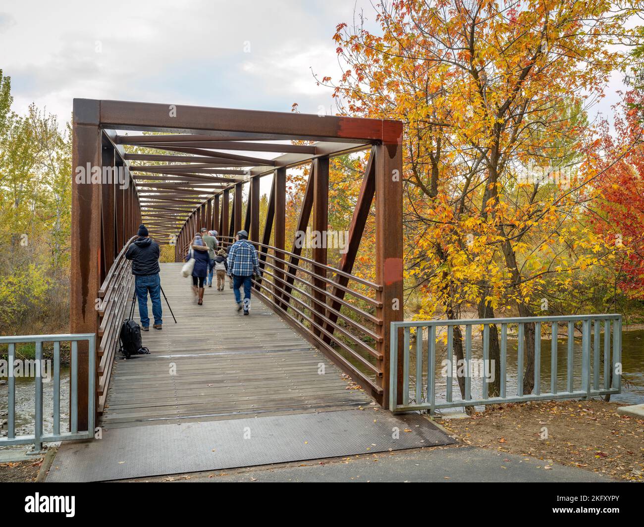 Herbstbäume entlang der Brücke über den Fluss Stockfoto