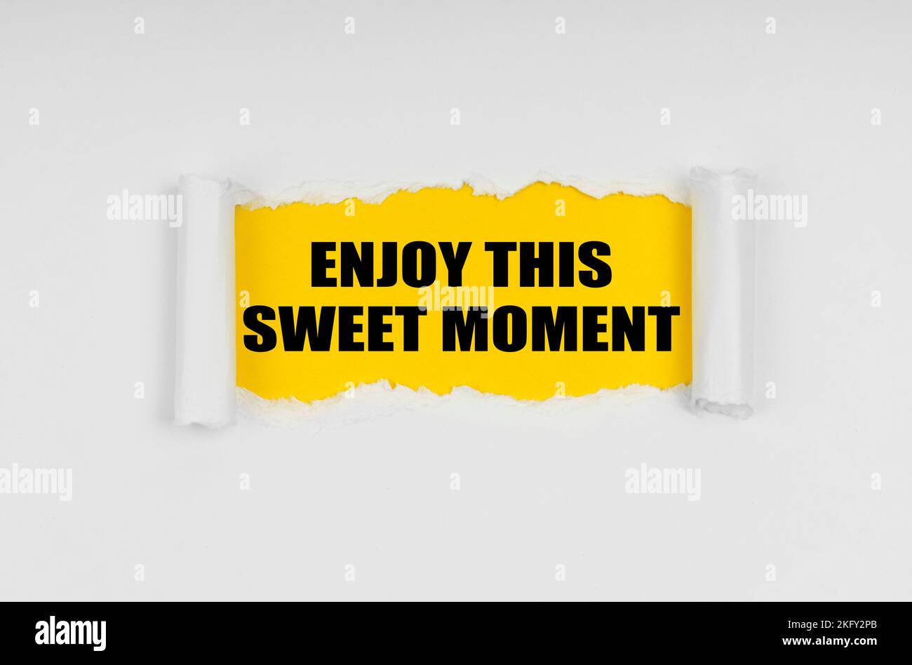 Urlaub und Menschen Konzept. Ein Fenster ist im Papier gemacht, wo auf einem gelben Hintergrund die Inschrift - Enjoy This Sweet Moment Stockfoto