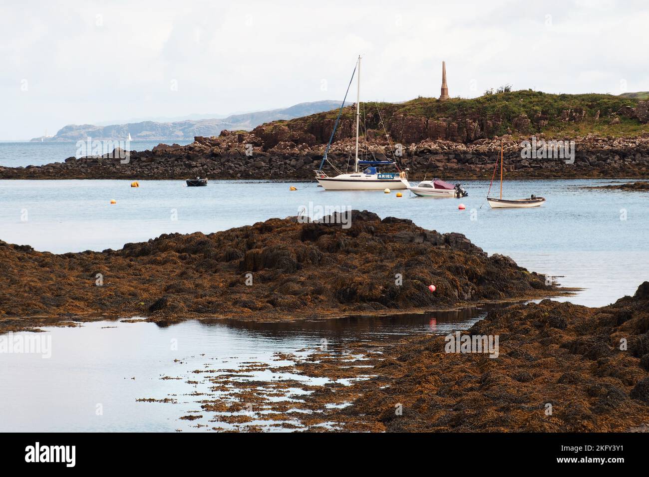 Ein Blick über das Meer bei Penmore mit verankerten Yachten, Mull, zum Ardnamurchan Leuchtturm am westlichsten Punkt Großbritanniens Stockfoto