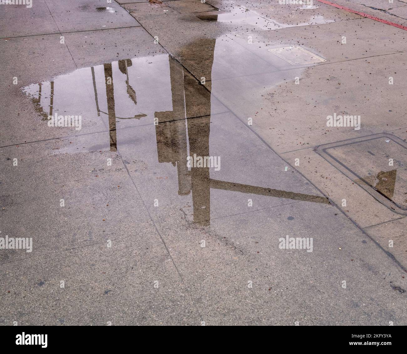 Eine große regen Pfütze Pools auf dem Boden in Dürre geritten Los Angeles. Stockfoto