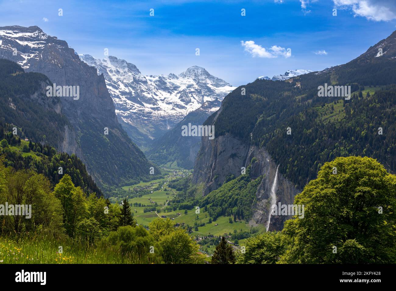 Landschaftsblick auf das Lauterbrunnen-Tal in der Schweiz. Der Staubbach-Wasserfall ist auf der rechten Seite zu sehen und die Schweizer Alpen im Hintergrund. Stockfoto