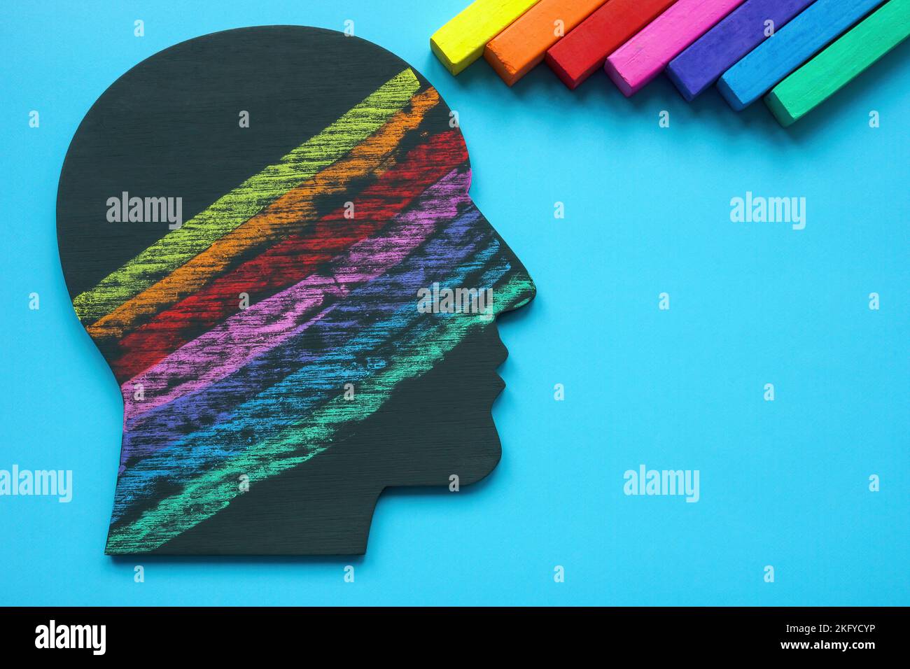 Kopf mit Linien, die mit farbigen Buntstiften gezeichnet sind. Positive Emotionen und Denkweise. Stockfoto