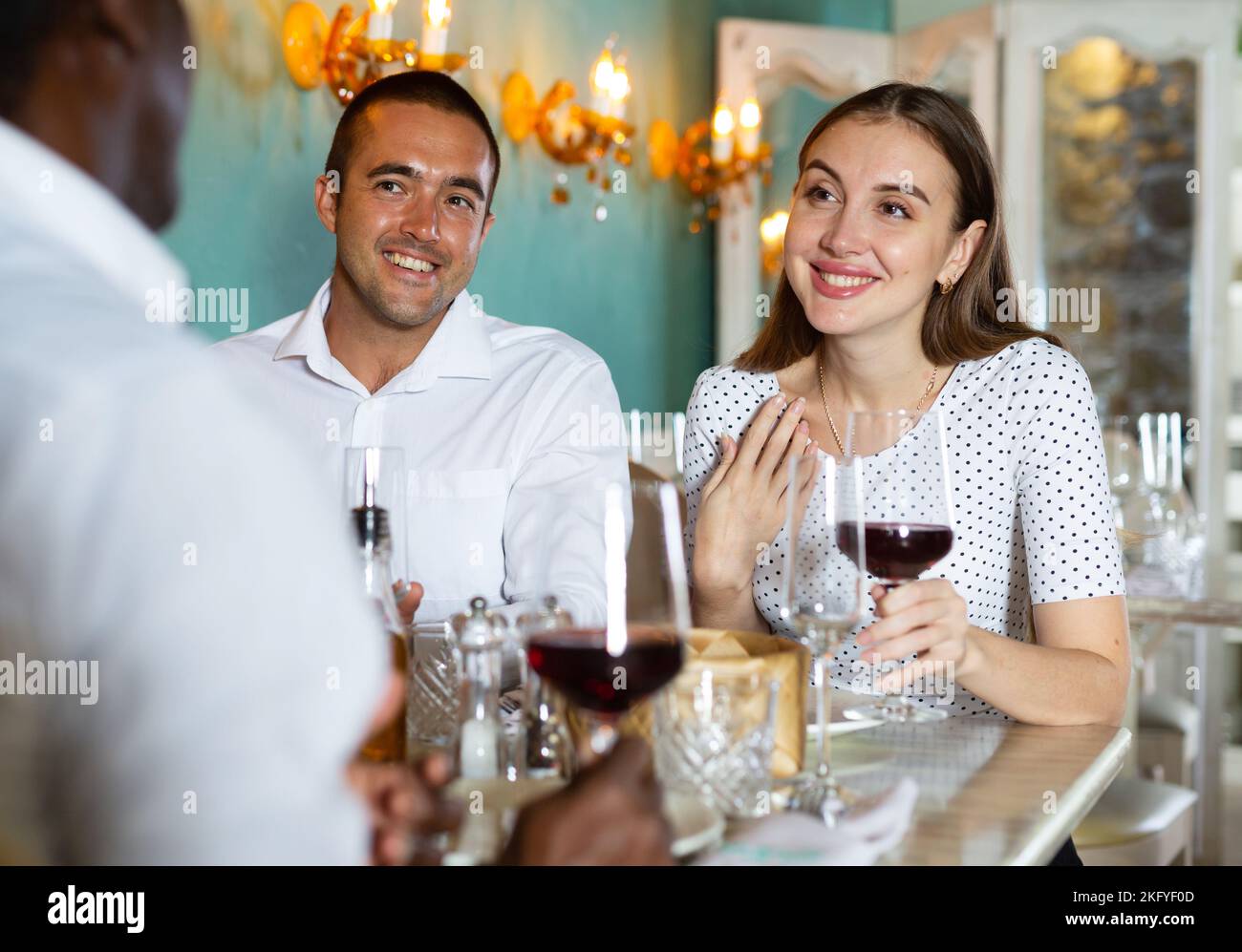 Eine Gruppe zufriedener Freunde, die das Abendessen im Restaurant genießen Stockfoto