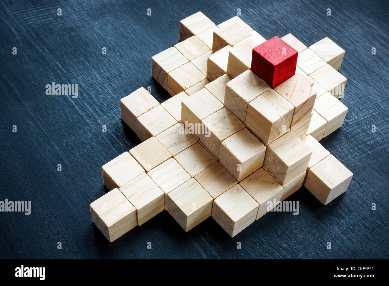 Eine Pyramide aus Würfeln und eine rote oben. Das Konzept von Führung, Erfolg und Unternehmenshierarchie. Stockfoto