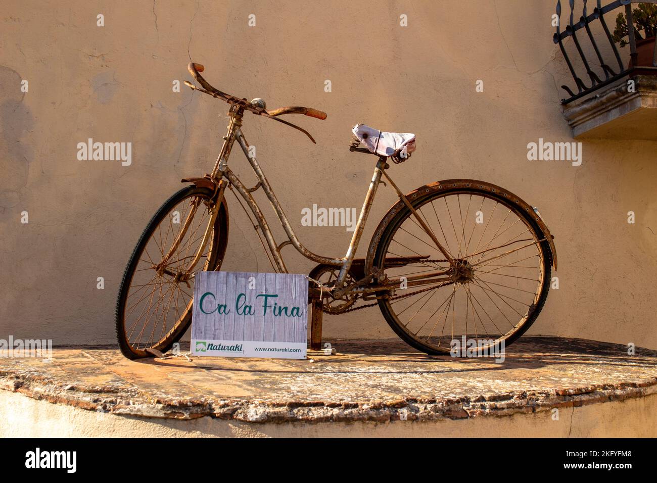 Ein altes Fahrrad, das für ein Ferienhaus Ca La Fina in der mittelalterlichen Stadt Pals wirbt Stockfoto