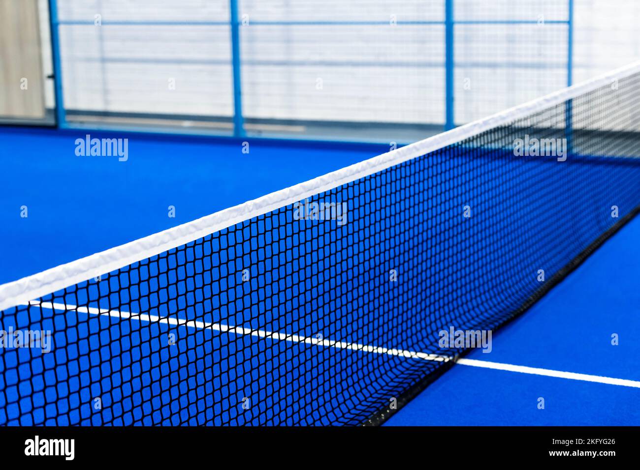 Paddeltennis und Tennisnetz auf dem Blue Court. Tenniskonzept. Horizontales Sportposter, Grußkarten, Header, Website Stockfoto