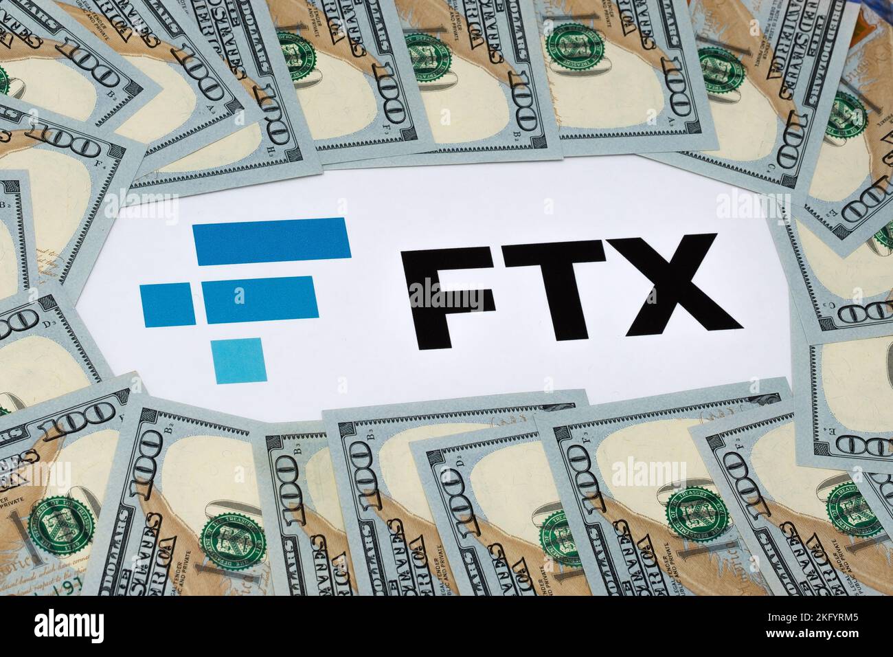 FTX Cryptocurrency Exchange-Logo auf Papier gedruckt und US-Dollar-Banknoten um ihn herum. Konzept für Firmenbankrott und Schulden. Stafford, United Kindom Stockfoto