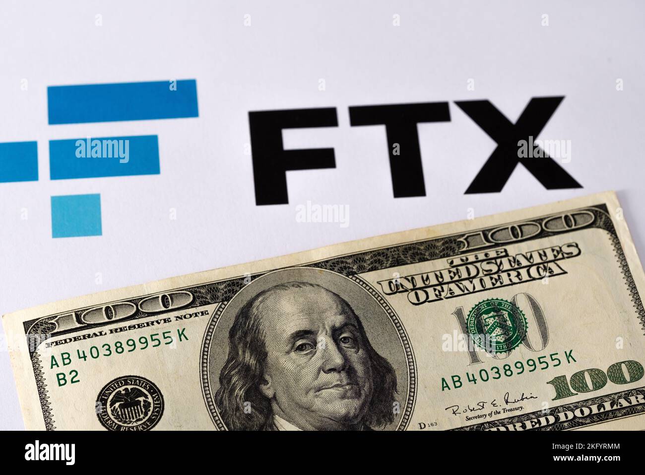 FTX Cryptocurrency Exchange-Logo auf Papier und daneben eine US-Dollar-Banknote. Konzept für Firmenbankrott und Schulden. Stafford, United Kindom, Stockfoto