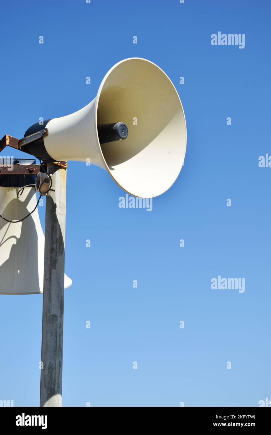 Alte verwitterte Vintage Beschallungs-(PA-)Megaphon-Lautsprecher und blauer Himmel. Stockfoto