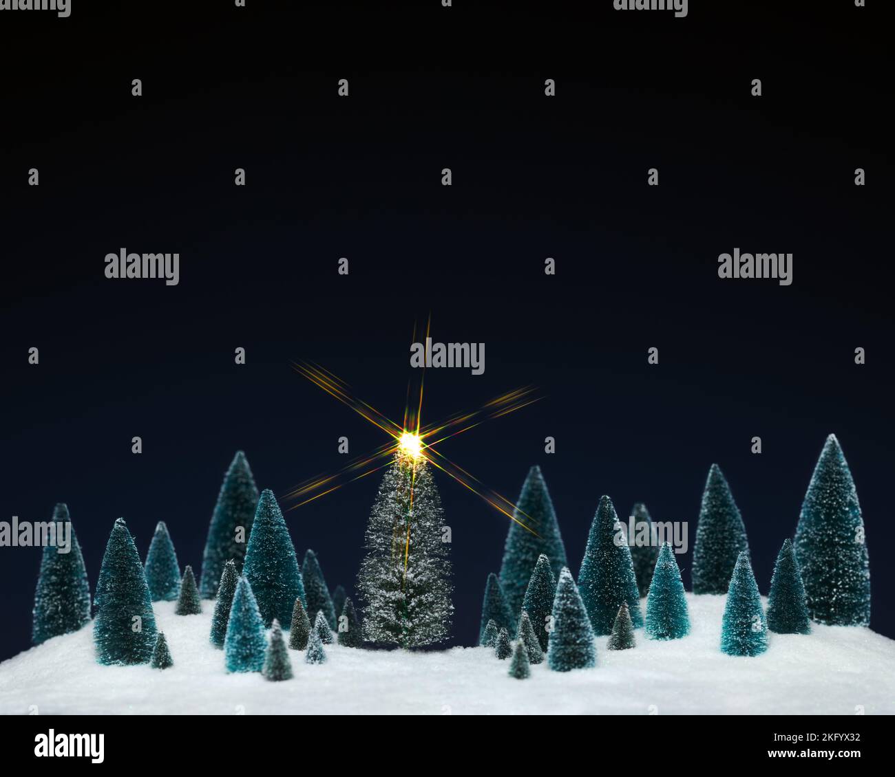 Miniatur-Baumschmuck mit einem funkelnden Stern auf dem Weihnachtsbaum. Stockfoto