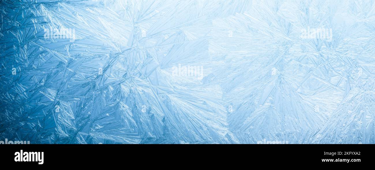 Winterfrostmuster auf Glas. Eiskristalle oder kalter Winterhintergrund. Stockfoto