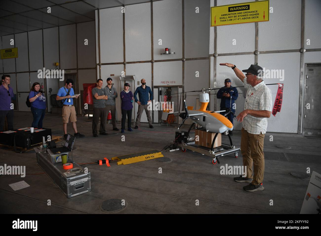 221016-N-DB801-0853 ATLANTIK – (OKT 16, 2022) – Jeff knapp, Chief Technology Officer von Unmanned Aerospace LLC, spricht im Rahmen des Flottenexperimentierungsprogramms (FLEX) der Marine im Atlantischen Ozean mit angesehenen Besuchern des Scientists-to-Sea-Programms über das GH4-Gyro-Flugzeug an Bord des Spearhead-Klasse Expeditionsschiffs USNS Burlington (T-EPF-10) im Rahmen des Flottenexperimentierungsprogramms (FLEX) der Marine, 16. Oktober, 2022. Stockfoto