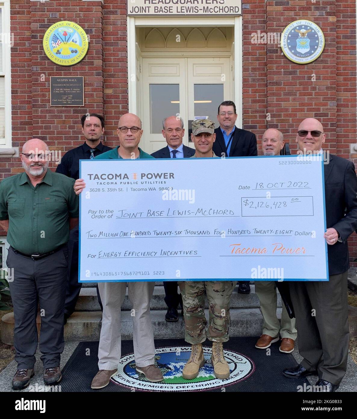 Paul Farnan, dritter von links, stellvertretender stellvertretender Sekretär der Armee (Installations, Energy and Environment), zusammen mit Colonel Phil Lamb, Center, Commander der Joint Base Lewis-McChord, und Vertretern von Tacoma Public Utilities, posieren mit dem Check während der Präsentation im JBLM am 18. Oktober. Verteidigungsministerium, JBLM News, Joint Base Lewis-McChord, Tacoma Power, Tacoma Public Utilities, Stockfoto