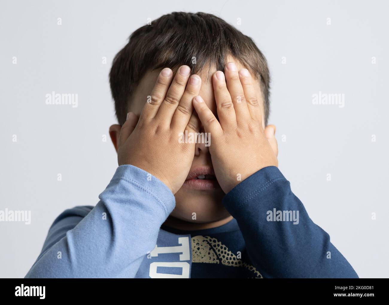Ein Mann, der etwa 4 Jahre alt ist und mit den Händen im Gesicht Emotionen ausdrückt Stockfoto