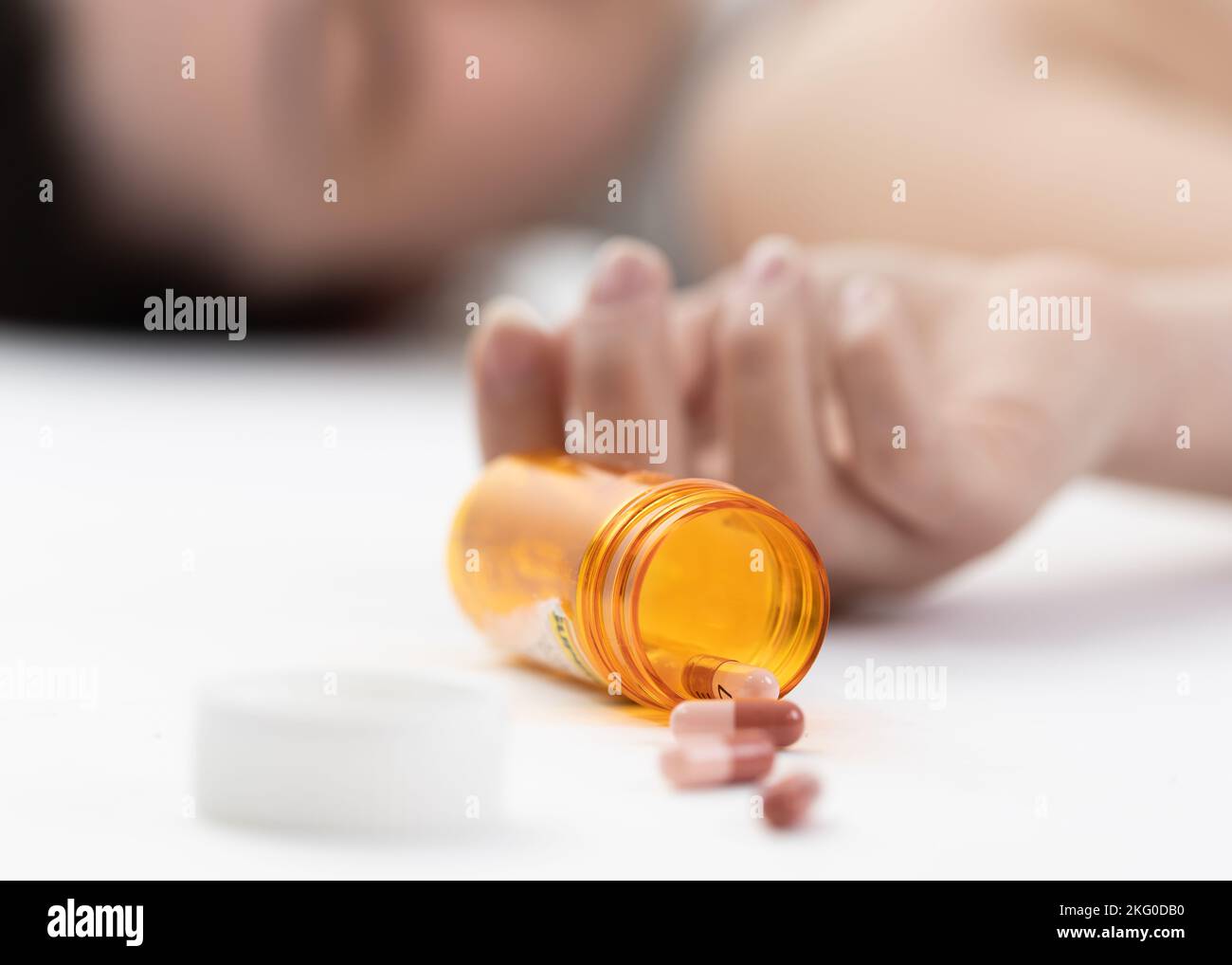 Szene eines Mädchens, das mit einer Überdosis Pille auf dem Boden liegt (absichtlicher selektiver Fokus) Stockfoto