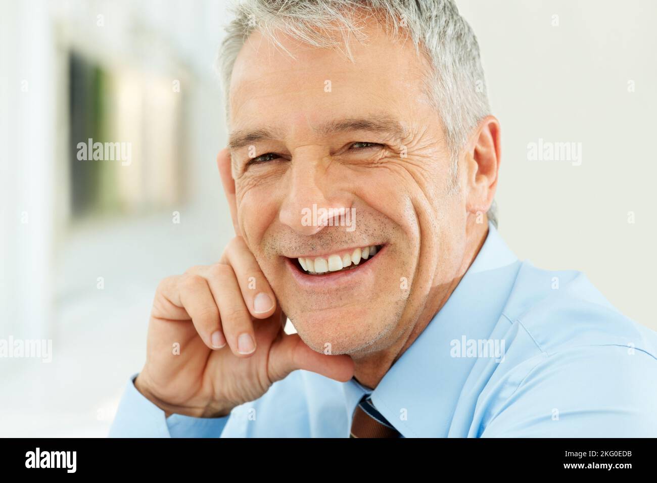 Nahaufnahme eines lächelnden Geschäftsmannes mittleren Alters. Nahaufnahme Porträt eines lächelnden Geschäftsmannes mittleren Alters im Büro. Stockfoto