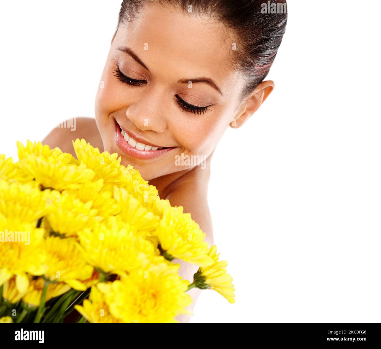 Geschenke eines heimlichen Verehrers. Eine schöne junge Frau, die einen Strauß gelber Blumen hält und ihre Schönheit vor weißem Hintergrund bewundert. Stockfoto